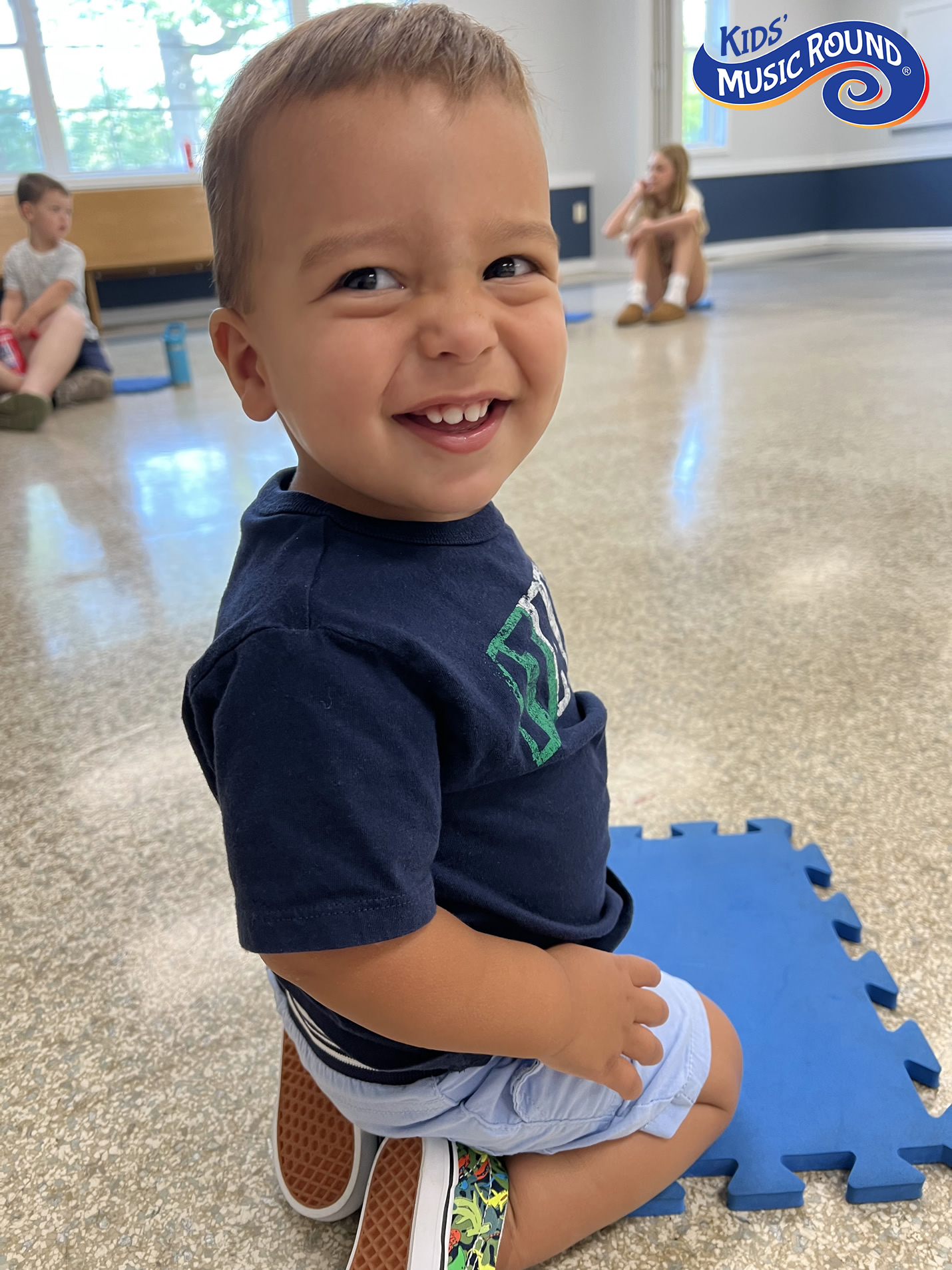 Boy kneeling on blue square
