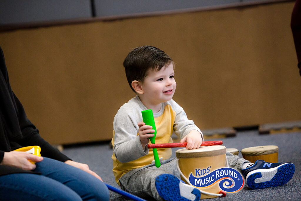 boy playing with homemade drumset