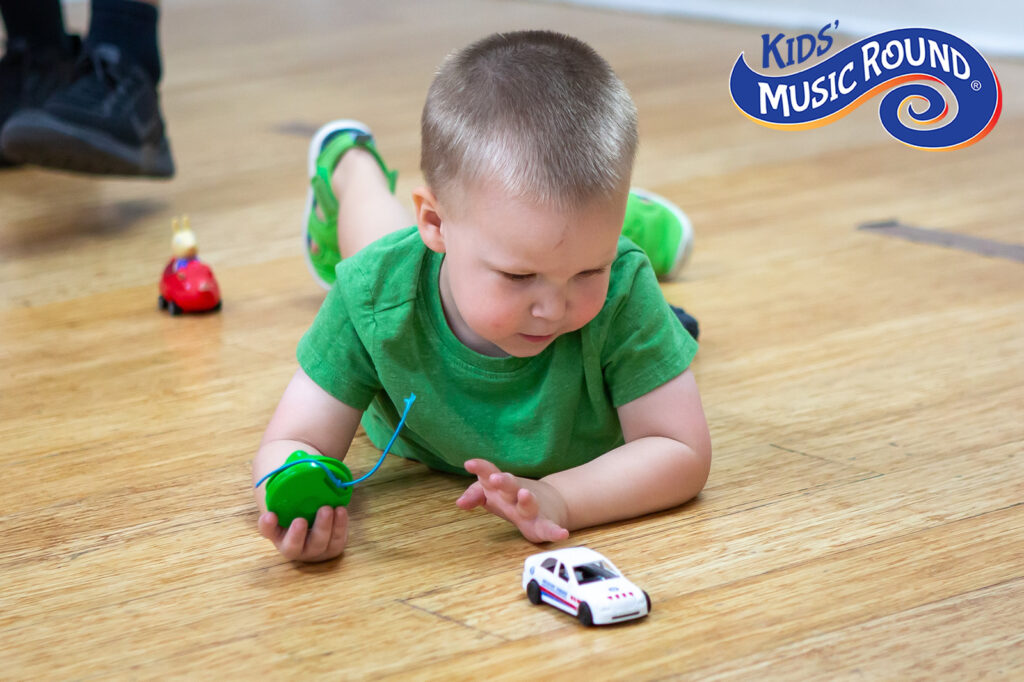 boy playing with toy car on floor